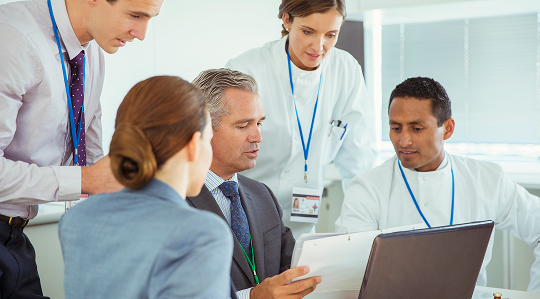 Metrology consulting services – team of engineers and scientists in discussion around laboratory table planning material testing and measurement strategy